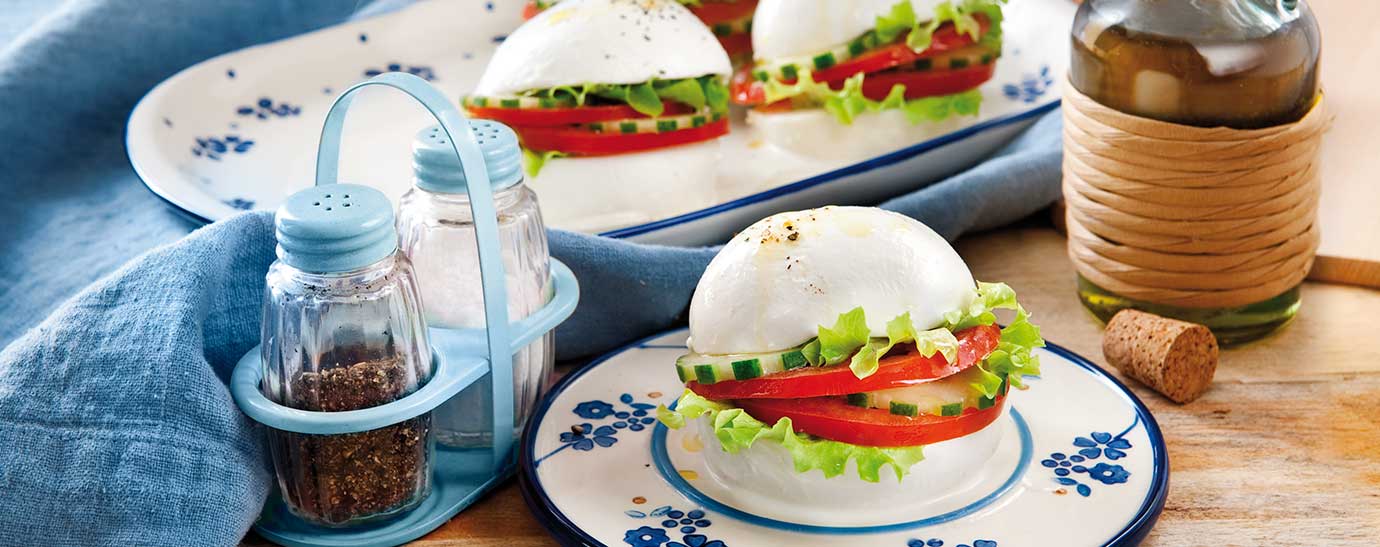 Sándwich de mozzarella con tomate, lechuga y pepino.