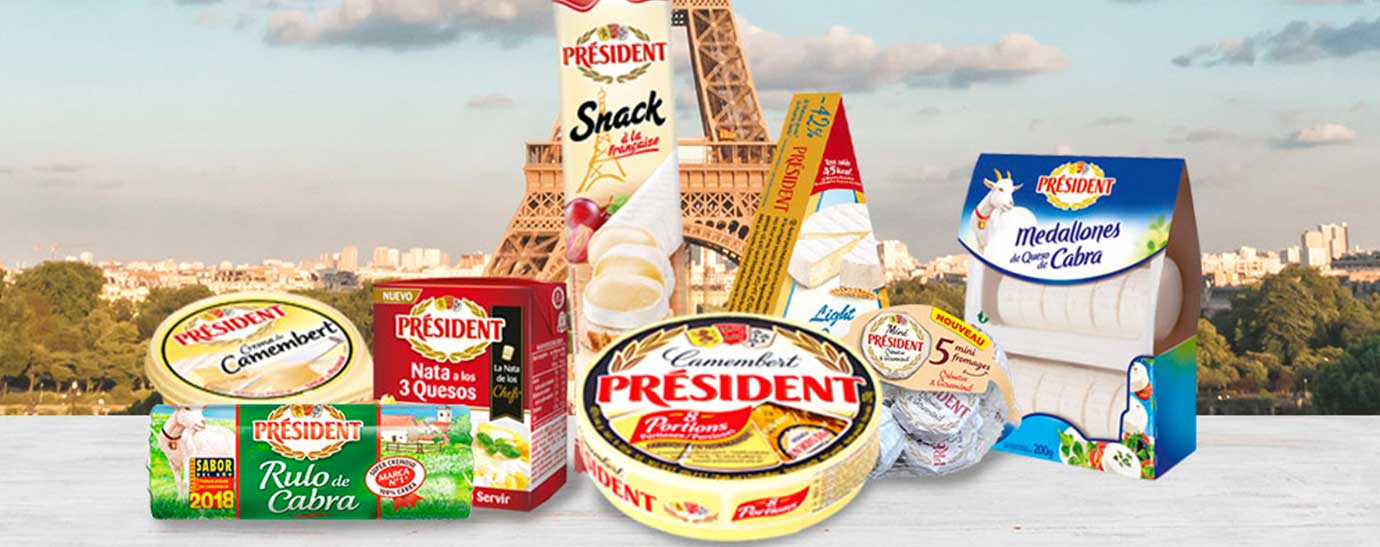 Bodegón de productos Président sobre una mesa de madera blanca y de fondo la Torre Eiffel